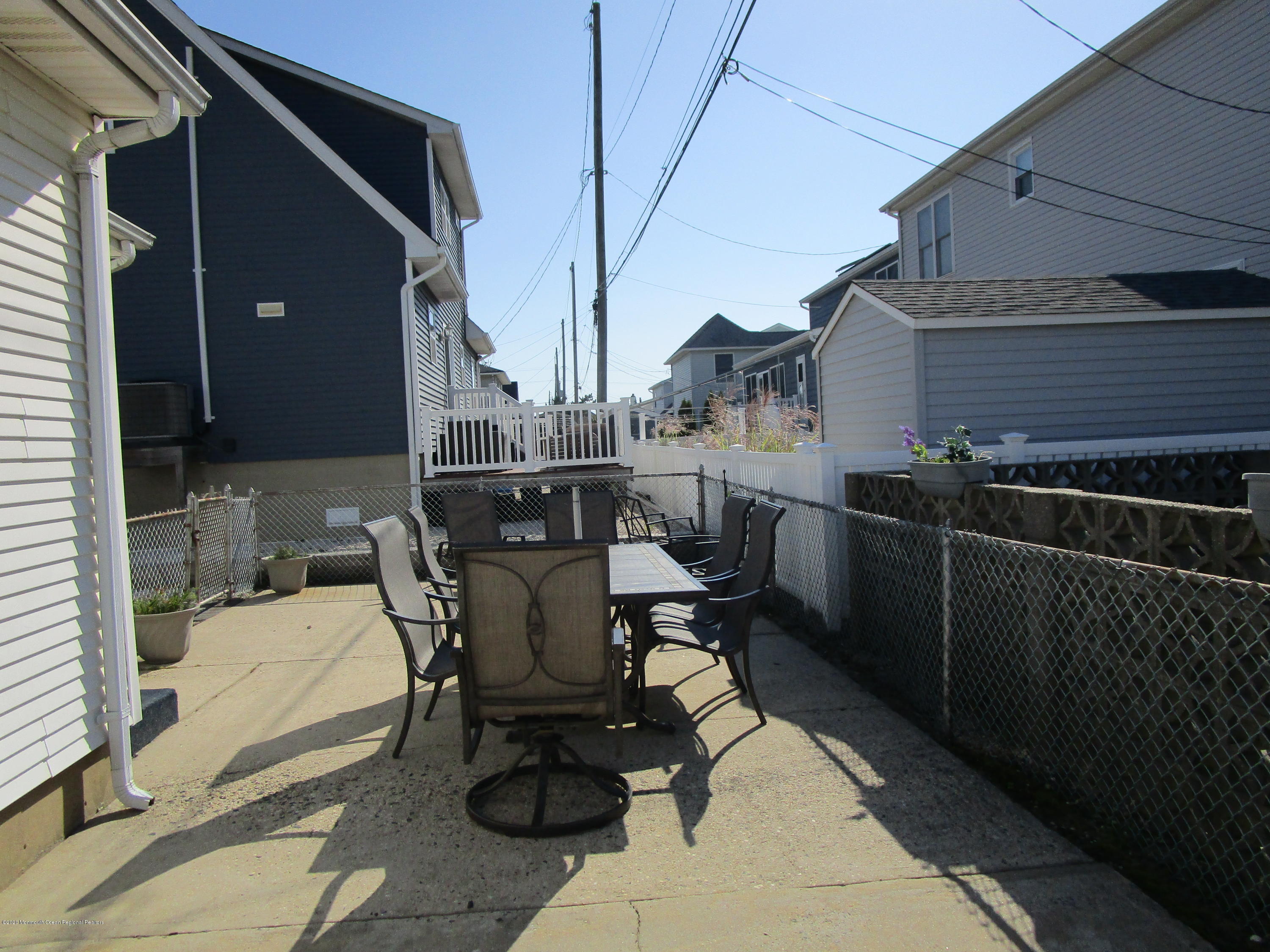 121 Jacobsen Lane Lavallette, NJ 08735 - Photo 18 of 19 a patio with table and chairs and potted plants