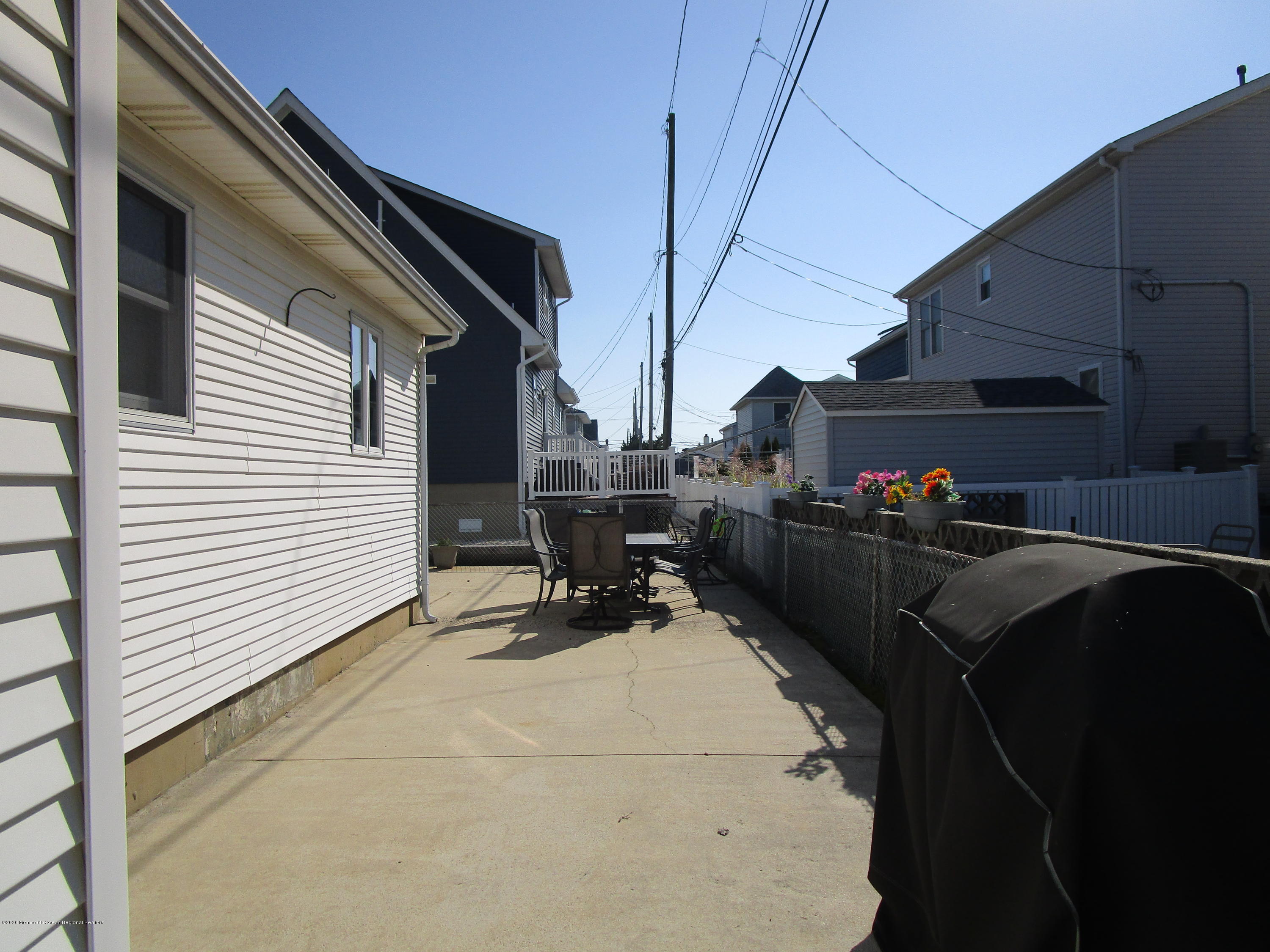 121 Jacobsen Lane Lavallette, NJ 08735 - Photo 19 of 19 a roof deck with table and chairs and potted plants