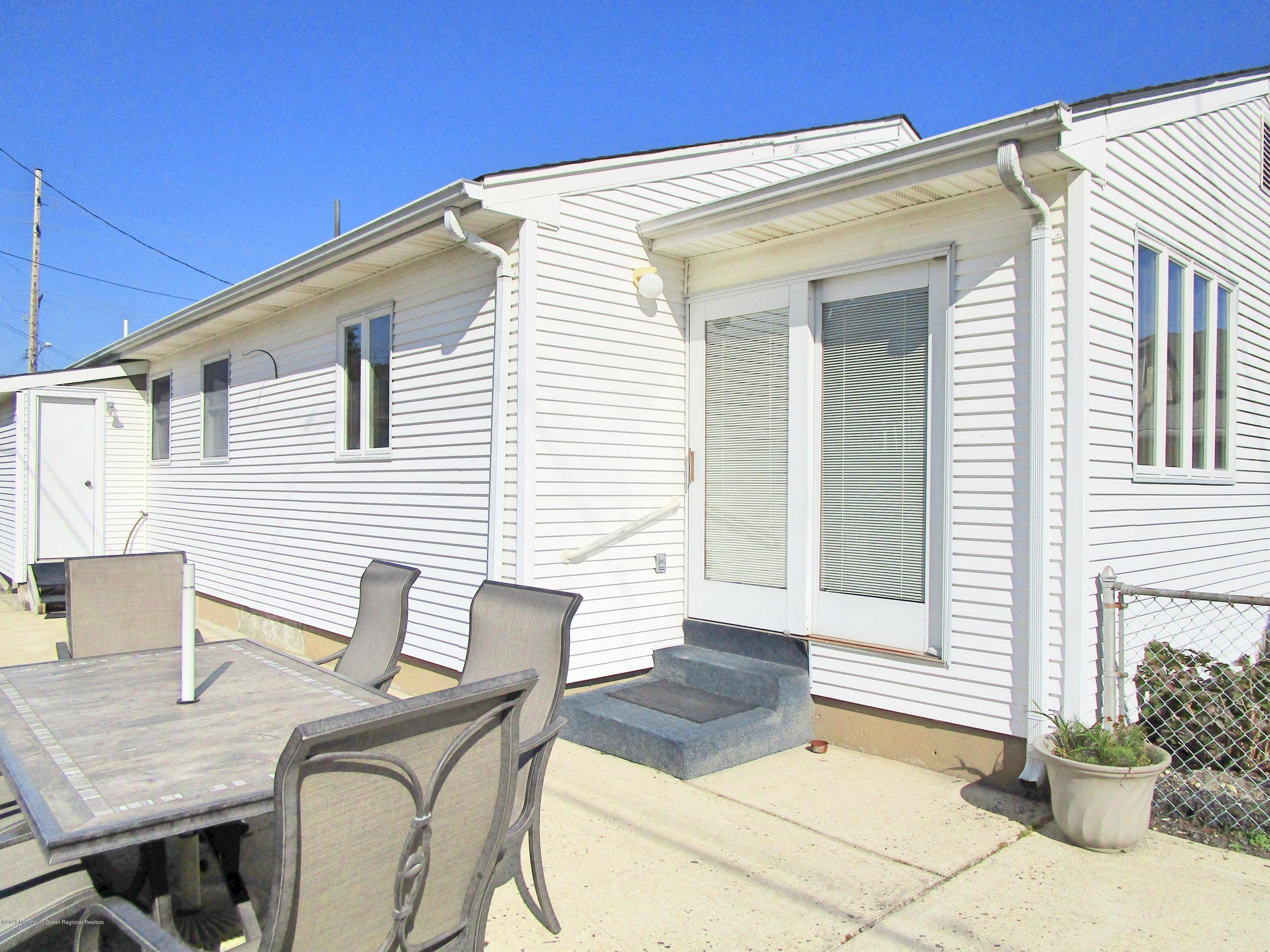 121 Jacobsen Lane Lavallette, NJ 08735 - Photo 3 of 19 a view of a patio with table and chairs and potted plants