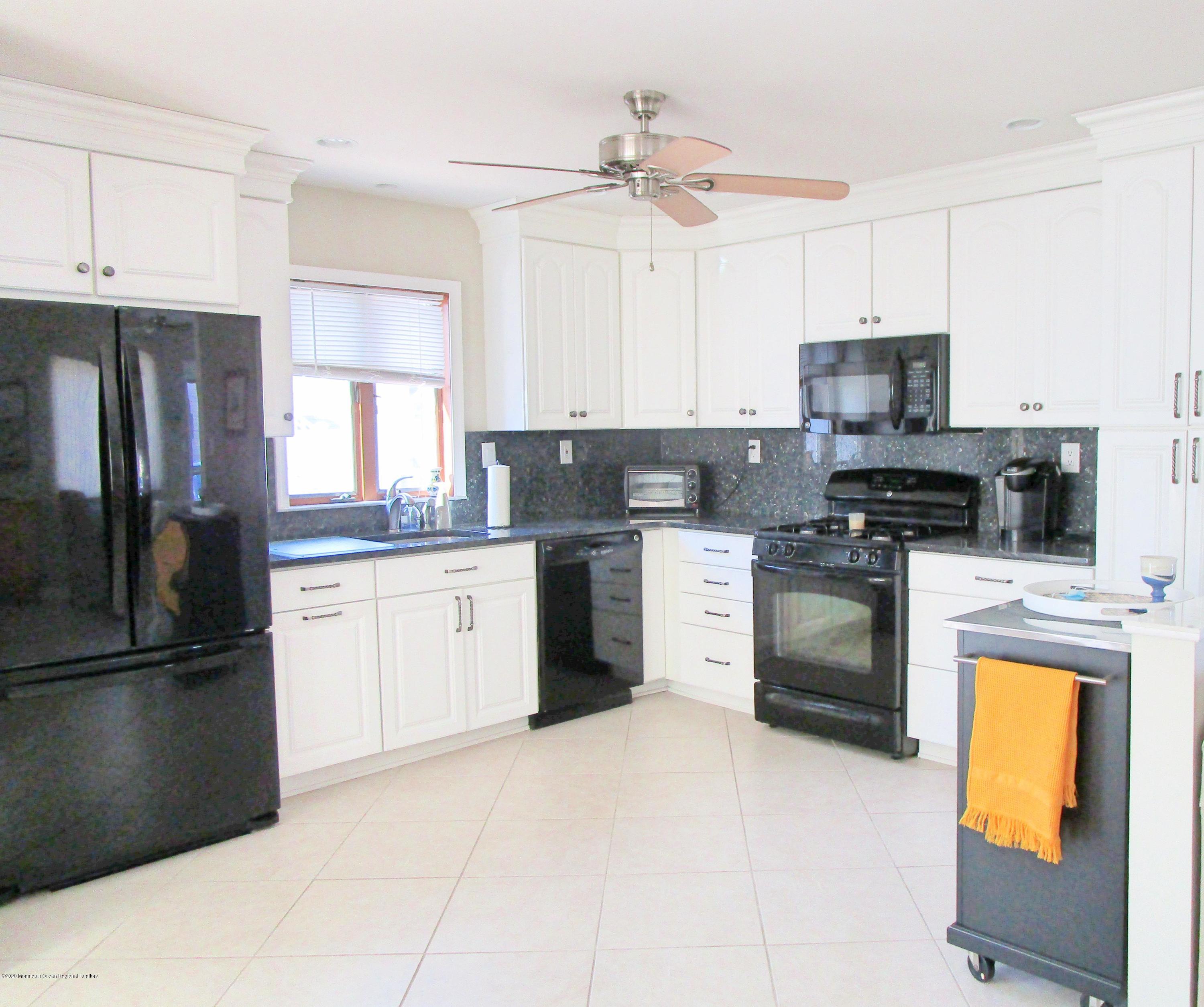 121 Jacobsen Lane Lavallette, NJ 08735 - Photo 5 of 19 a kitchen with stainless steel appliances granite countertop a refrigerator a stove a sink and a microwave