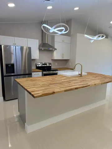 a kitchen with stainless steel appliances granite countertop a sink a stove and a refrigerator