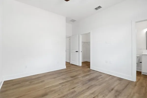 an empty room with a window and wooden floor