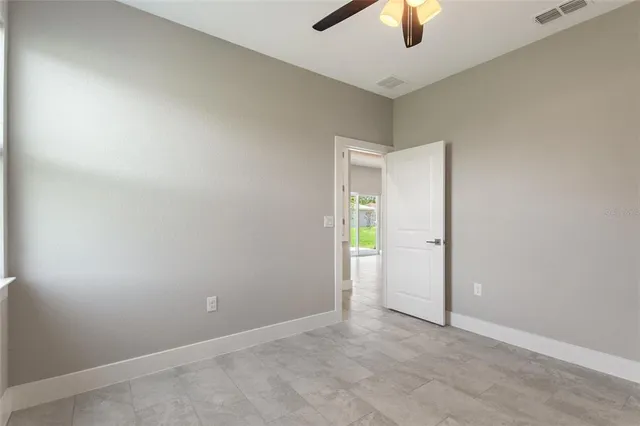 an empty room with closet and a chandelier fan