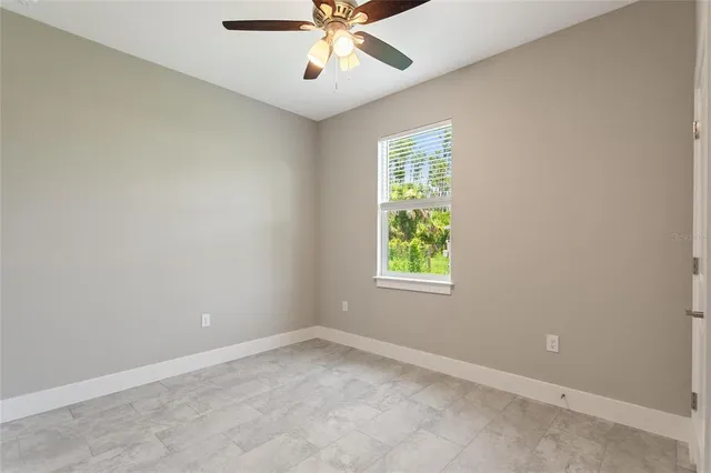 an empty room with a window and a fan