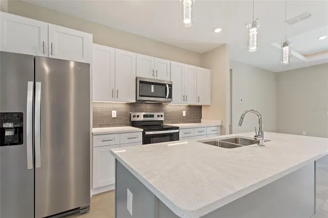 a kitchen with stainless steel appliances a refrigerator sink and microwave