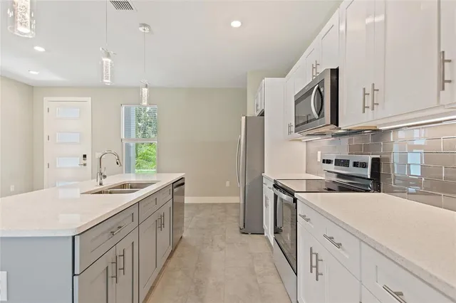 a kitchen with stainless steel appliances granite countertop a sink stove and cabinets