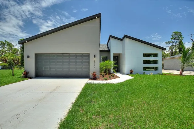 a front view of house with yard and a garage