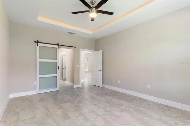 an empty room with closet and a ceiling fan
