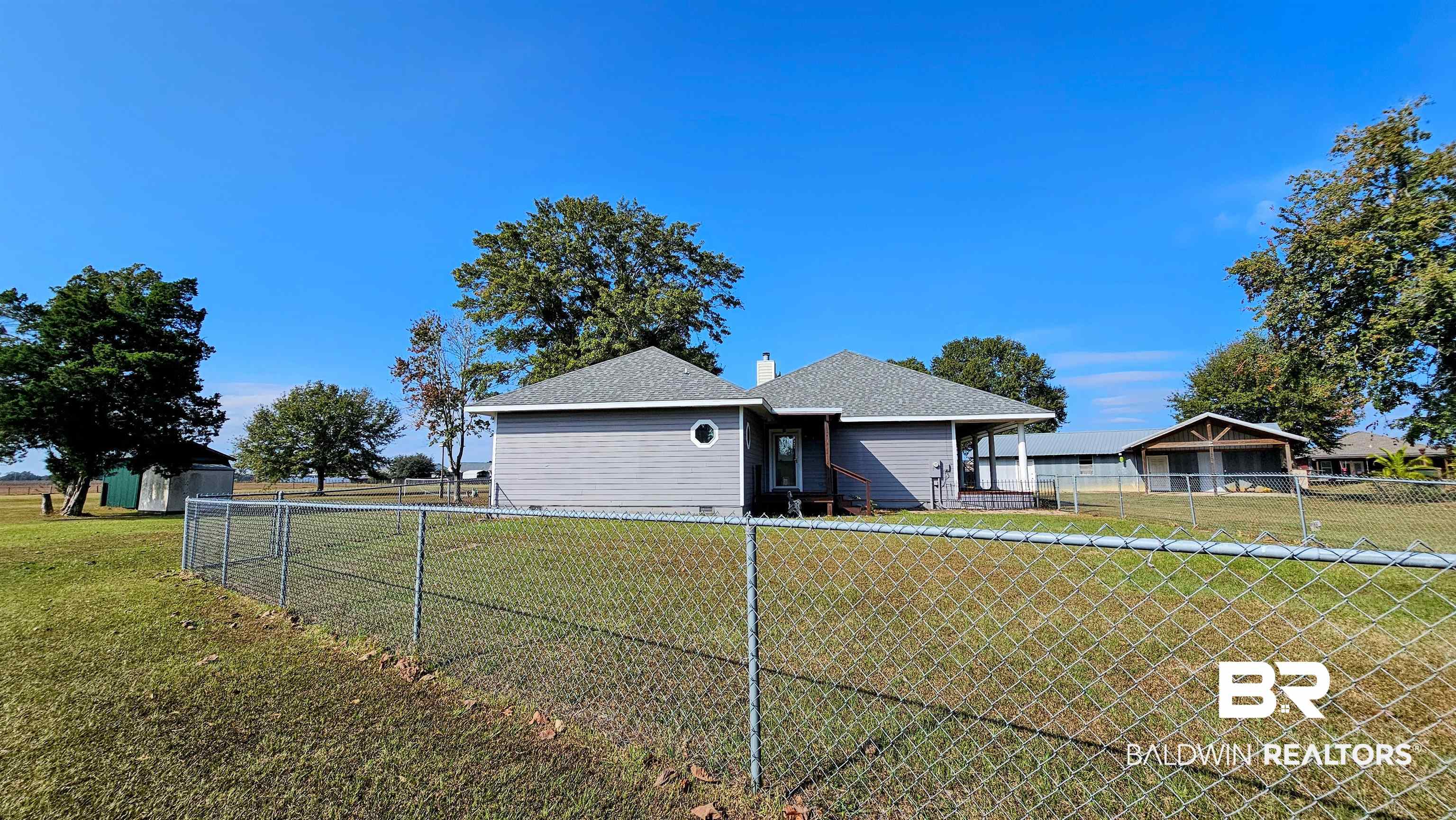 9275 Crawford Road Elberta, AL 36530 - Photo 9 of 28 Back of property with a fenced backyard, a chimney, and a shingled roof