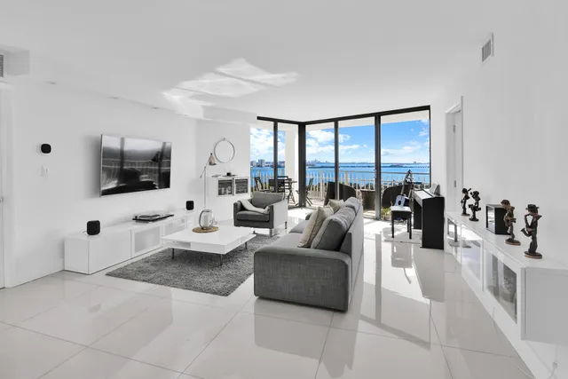 a living room with furniture large windows and a flat screen tv