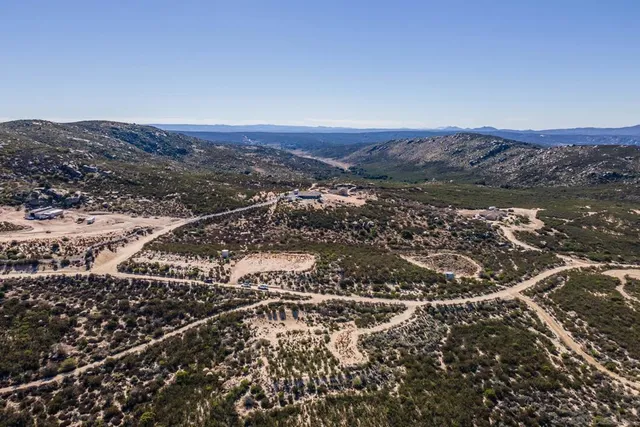 an aerial view of residential house and mountain view in back