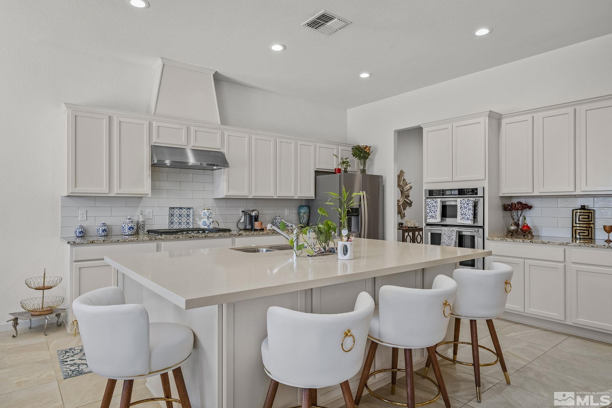 3080 Show Jumper Lane Reno, NV 89521 - Photo 11 of 40 a kitchen with stainless steel appliances a table chairs refrigerator and cabinets
