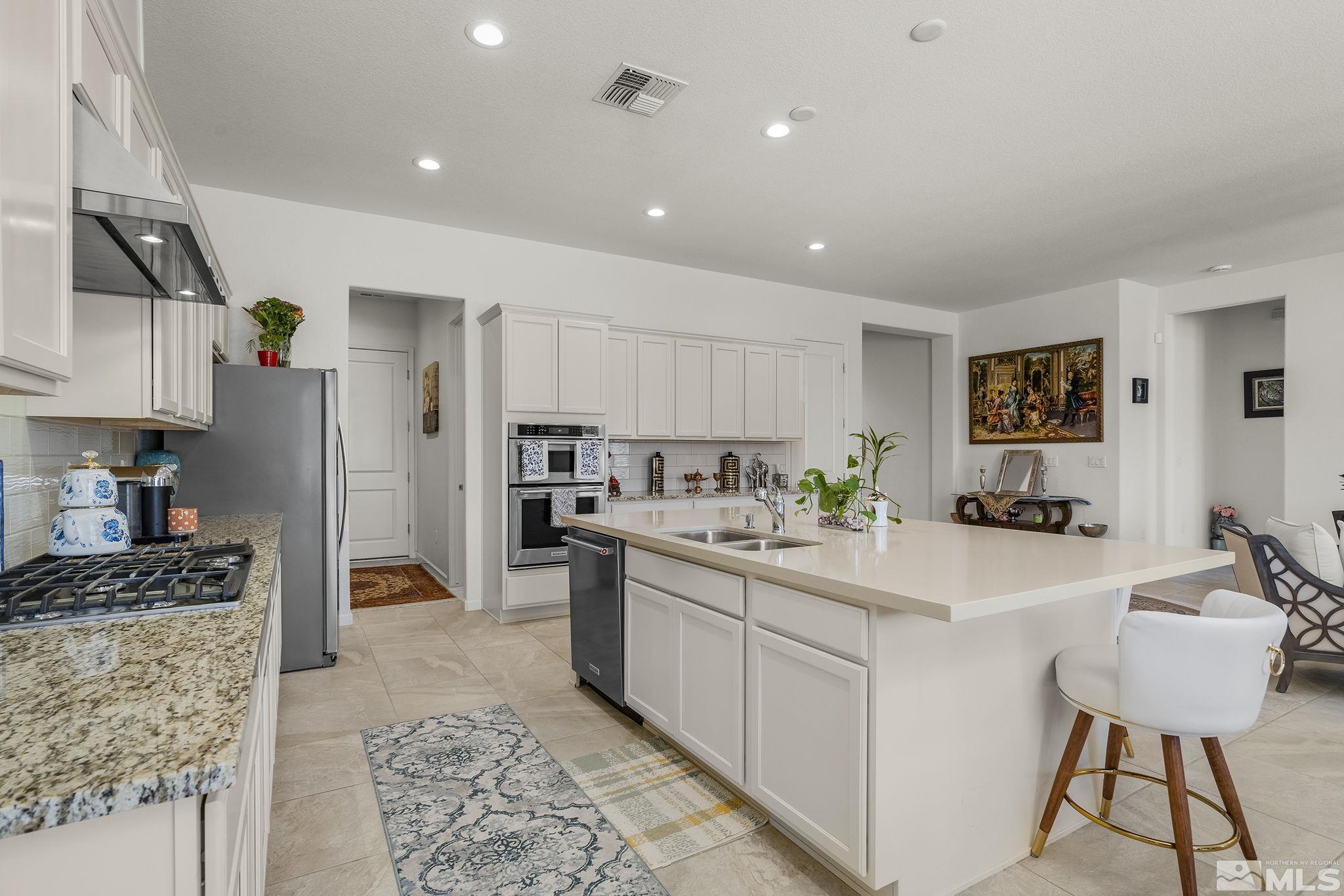 3080 Show Jumper Lane Reno, NV 89521 - Photo 12 of 40 a kitchen with stainless steel appliances kitchen island granite countertop a sink and cabinets