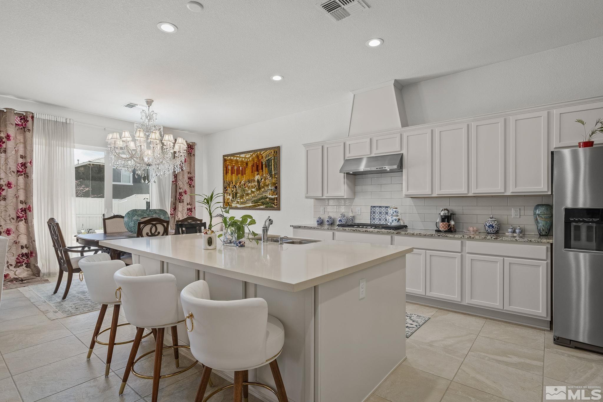 3080 Show Jumper Lane Reno, NV 89521 - Photo 9 of 40 a kitchen with white cabinets and chairs
