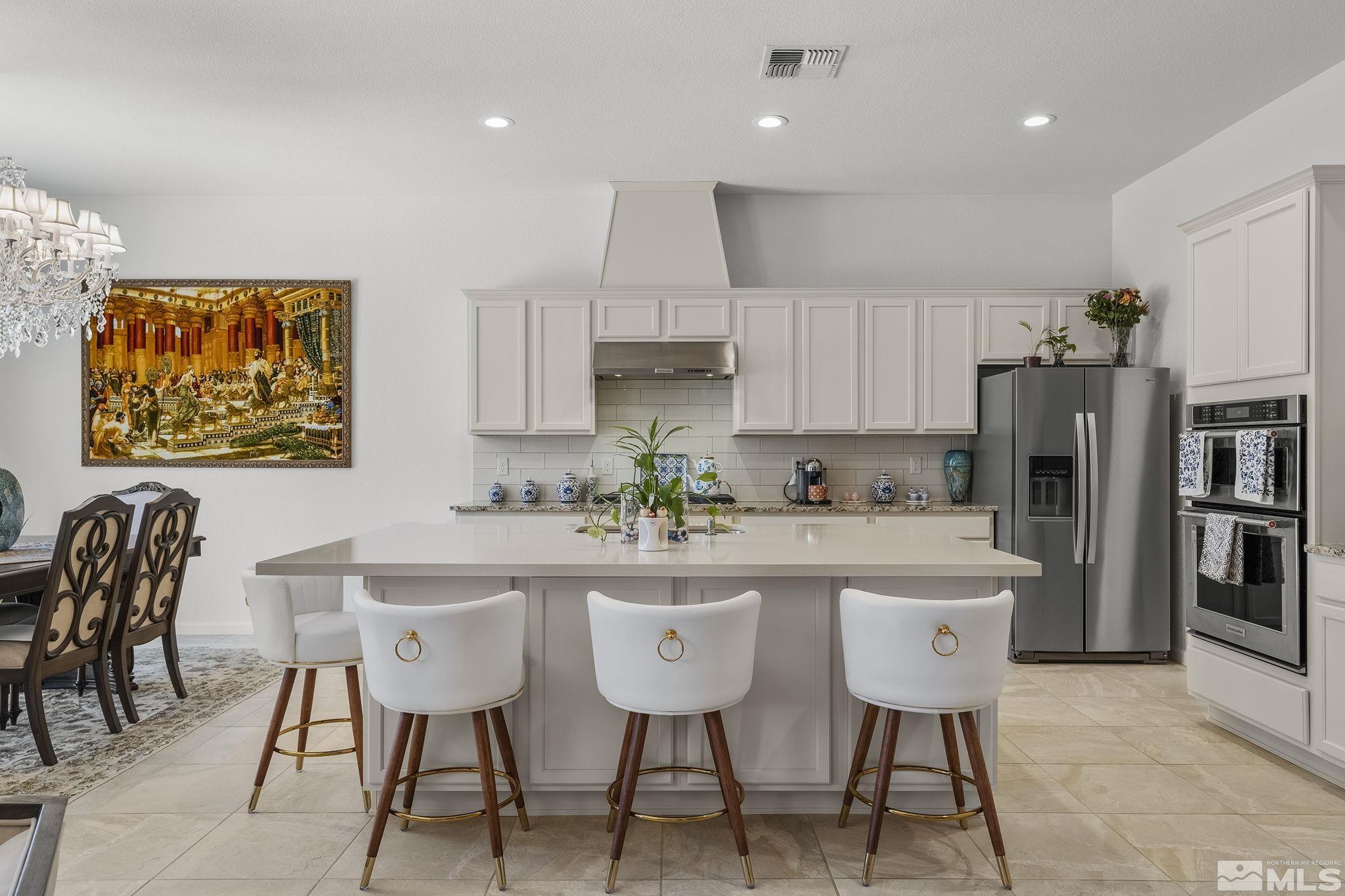 3080 Show Jumper Lane Reno, NV 89521 - Photo 10 of 40 a kitchen with stainless steel appliances granite countertop a table chairs refrigerator and a sink