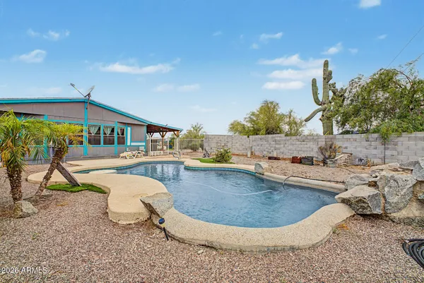 a view of a swimming pool with a patio and a yard