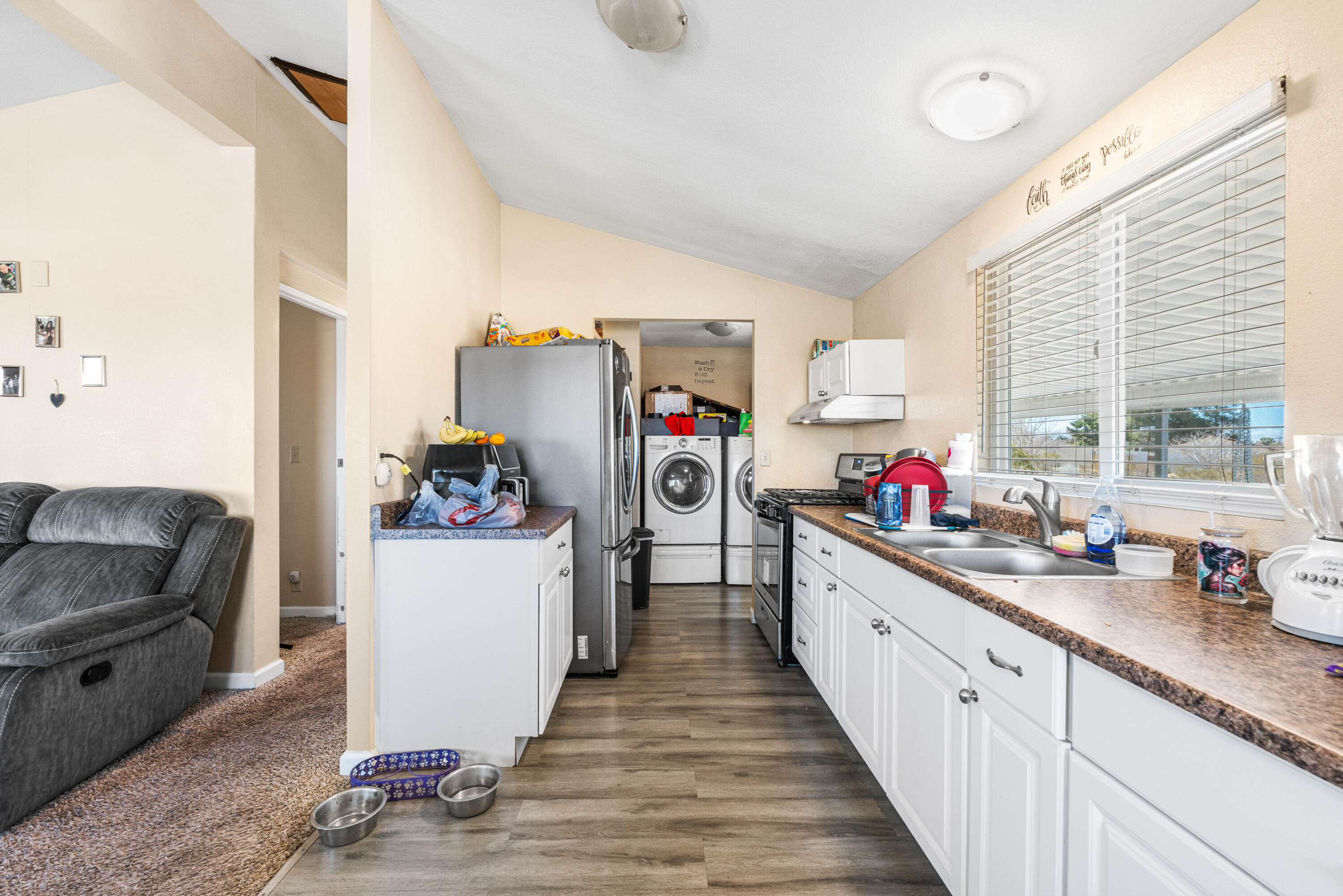 4824 Sacramento Road Phelan, CA 92371 - Photo 13 of 28 a kitchen with granite countertop lots of clutter and stainless steel appliances