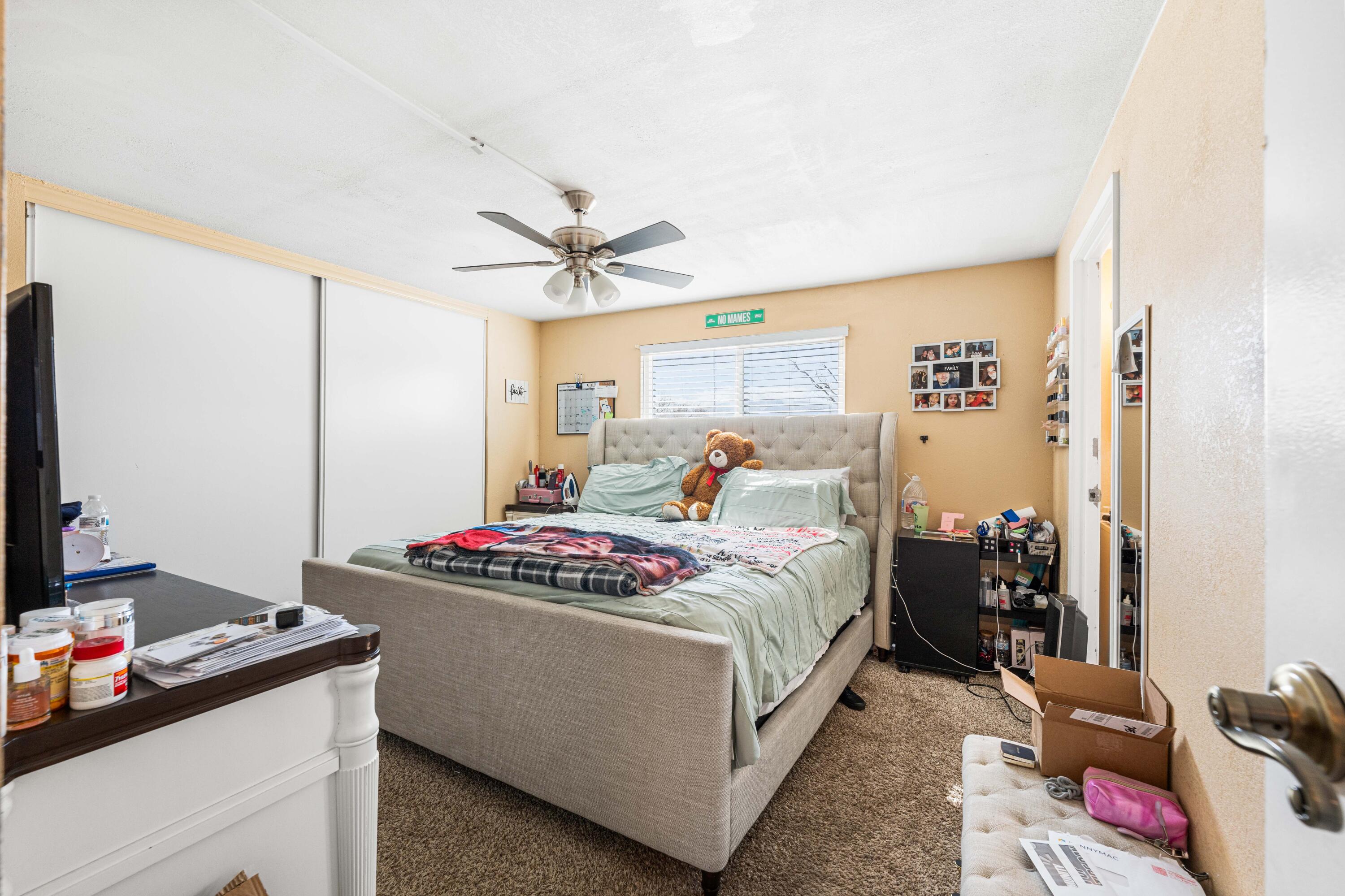 4824 Sacramento Road Phelan, CA 92371 - Photo 15 of 28 a bedroom with a bed and a chandelier