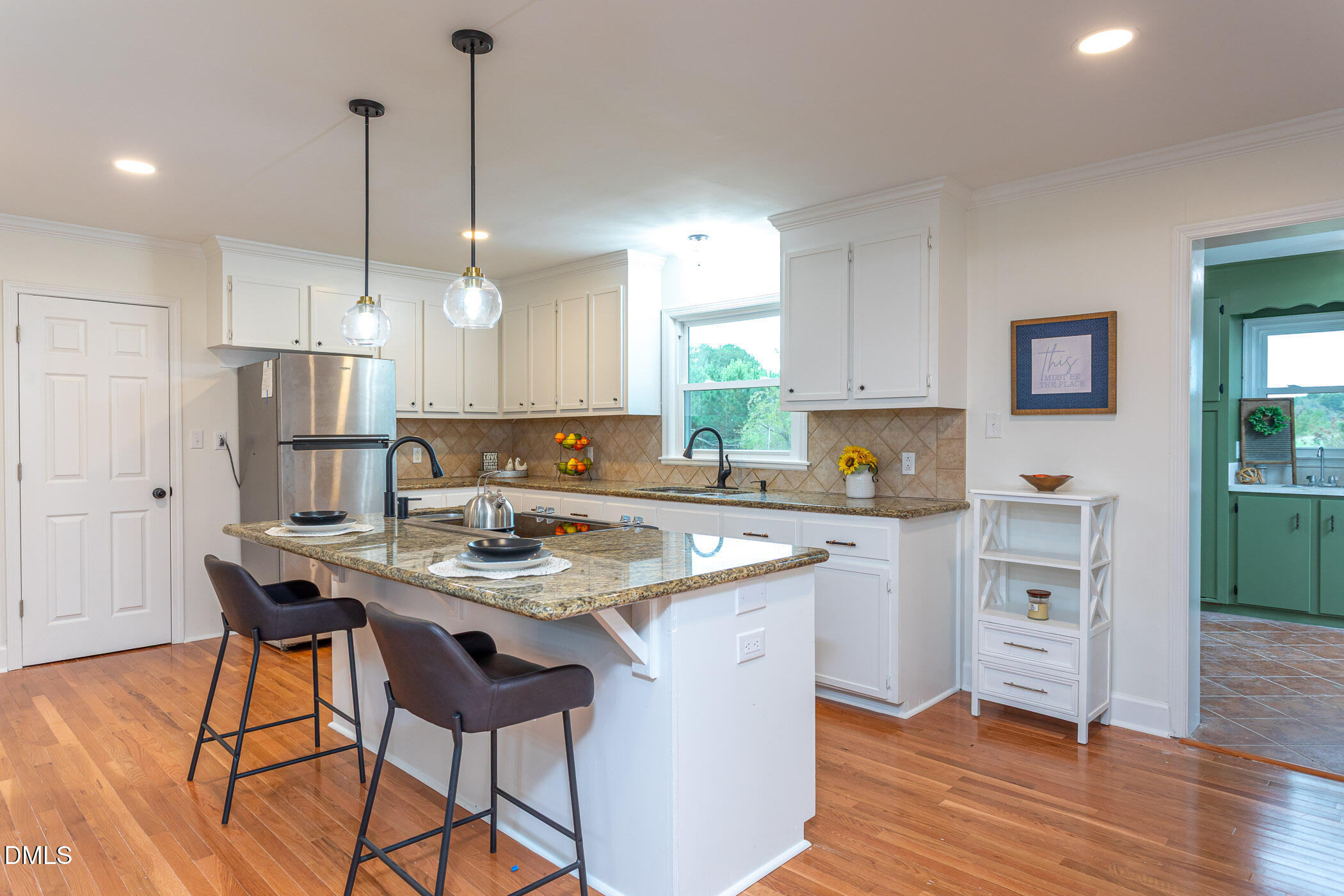 641 Rocky Ford Road Louisburg, NC 27549 - Photo 2 of 40 a kitchen with a stove a refrigerator a sink a dining table and chairs with wooden floor