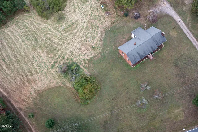 a front view of house with yard and trees in the background