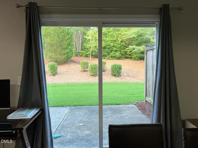 a view of a porch with a table chairs and a yard