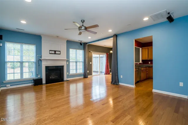 a view of a livingroom with a fireplace wooden floor and windows