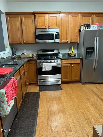 a kitchen with stainless steel appliances a stove a sink and a microwave