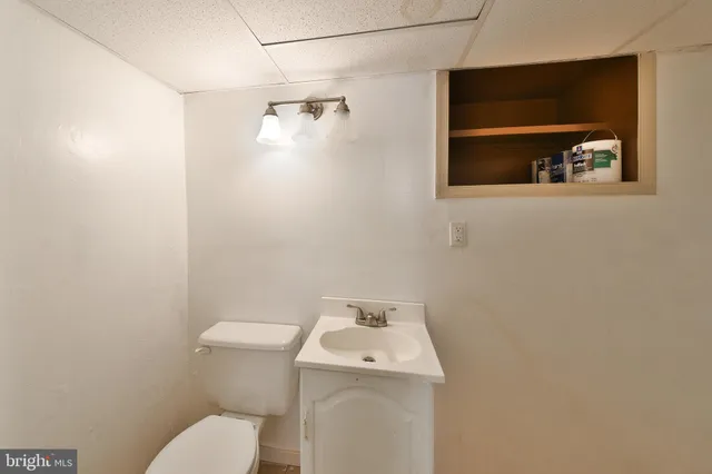 a bathroom with a toilet sink and mirror