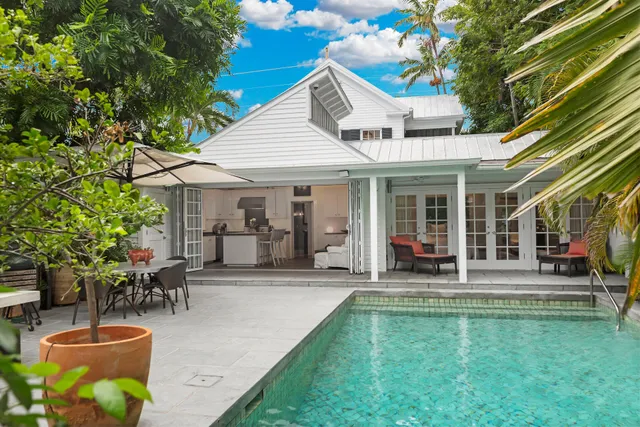 a view of a patio with table and chairs potted plants and palm trees