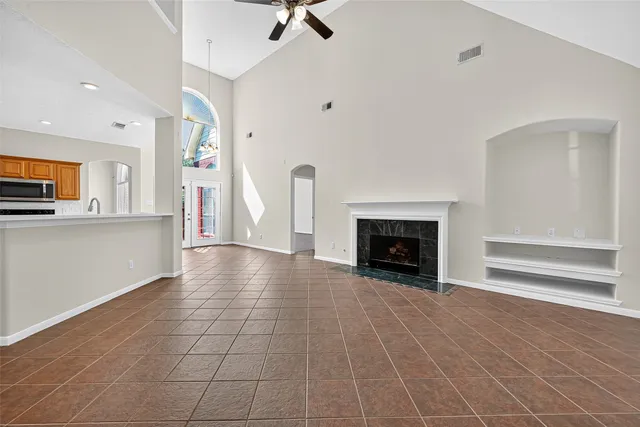 a view of an empty room with a fireplace and a window