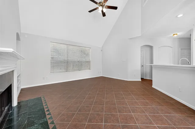 an empty room with windows and fireplace