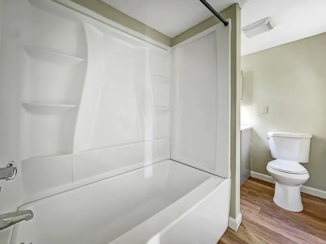 a bathroom with a white toilet and a shower
