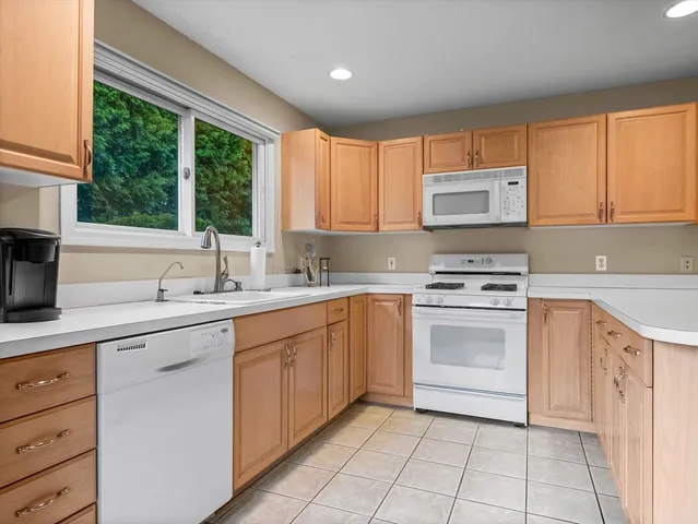 a kitchen with cabinets appliances a sink and a window