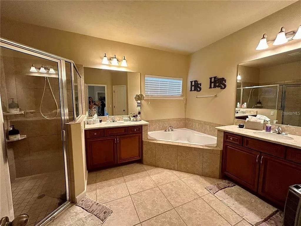 9883 Northwest 17th Road Gainesville, FL 32606 - Photo 8 of 11 a bathroom with a tub sink shower and mirror