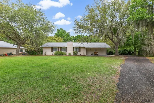 a front view of house with yard and green space