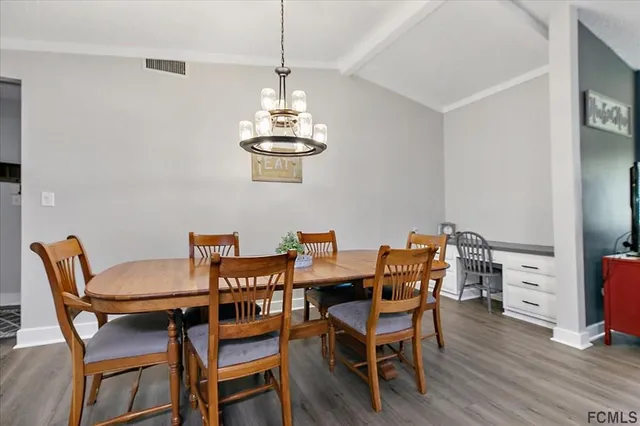 a view of a dining room with furniture wooden floor and chandelier