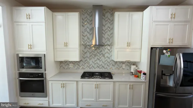 a kitchen with stainless steel appliances white cabinets and a refrigerator