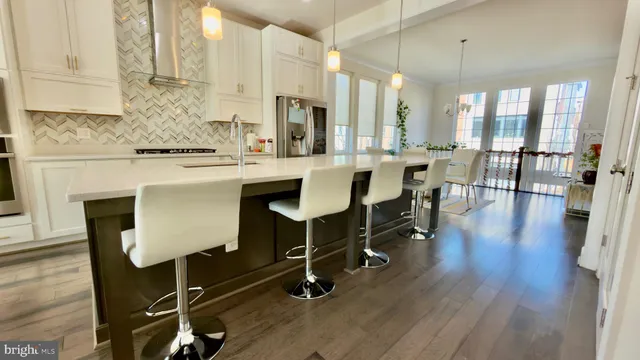 a kitchen with stainless steel appliances granite countertop a table chairs stove a sink and dishwasher