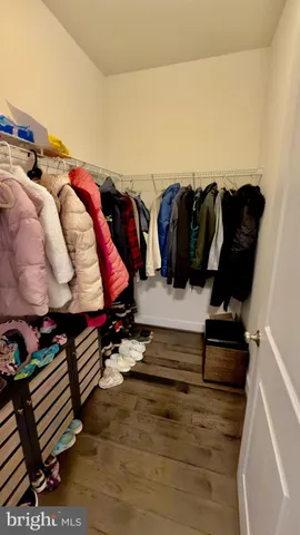 a view of walk in closet with clothes and shoes