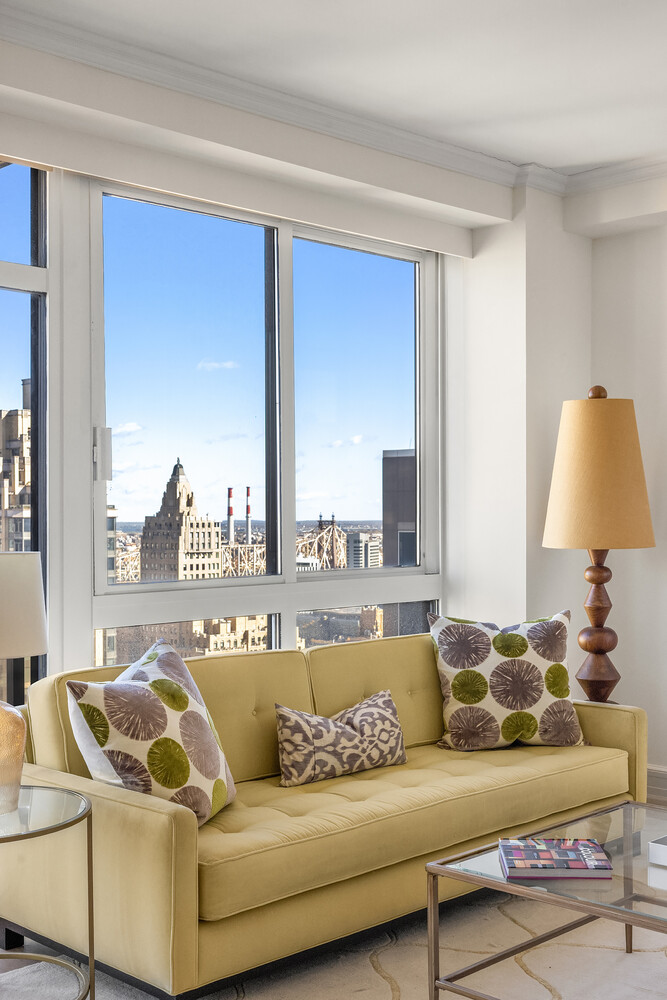 100 United Nations Plaza, Unit 35E Manhattan, NY 10017 - Photo 5 of 11 a living room with furniture and a large window