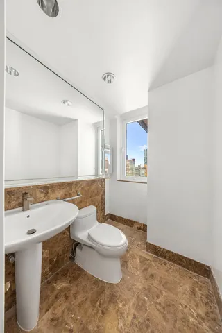 a bathroom with a granite countertop sink a toilet and a mirror