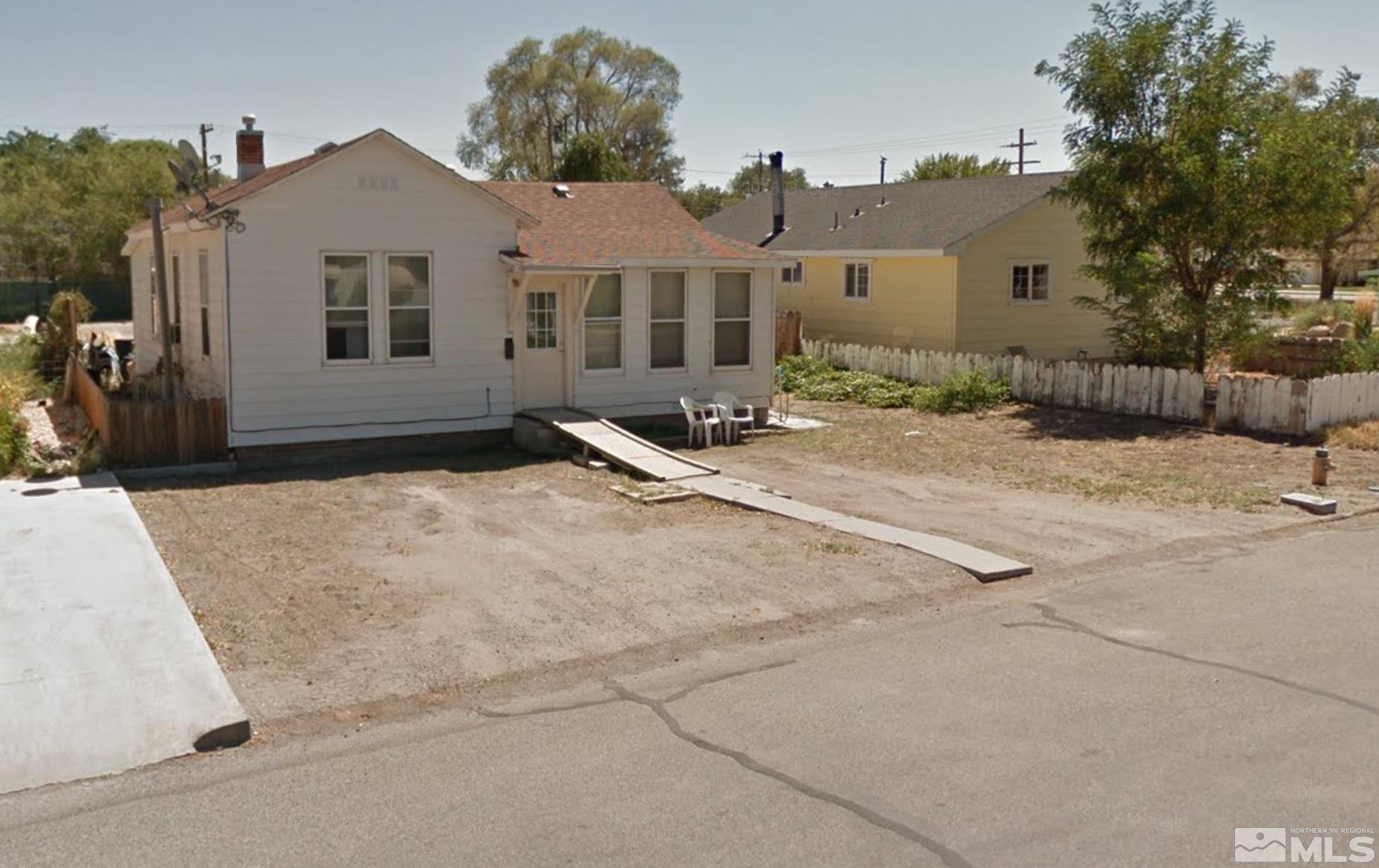 220 South Nevada Street, Unit 3 Yerington, NV 89447 - Photo 22 of 39 a front view of a house with yard and trees in the background