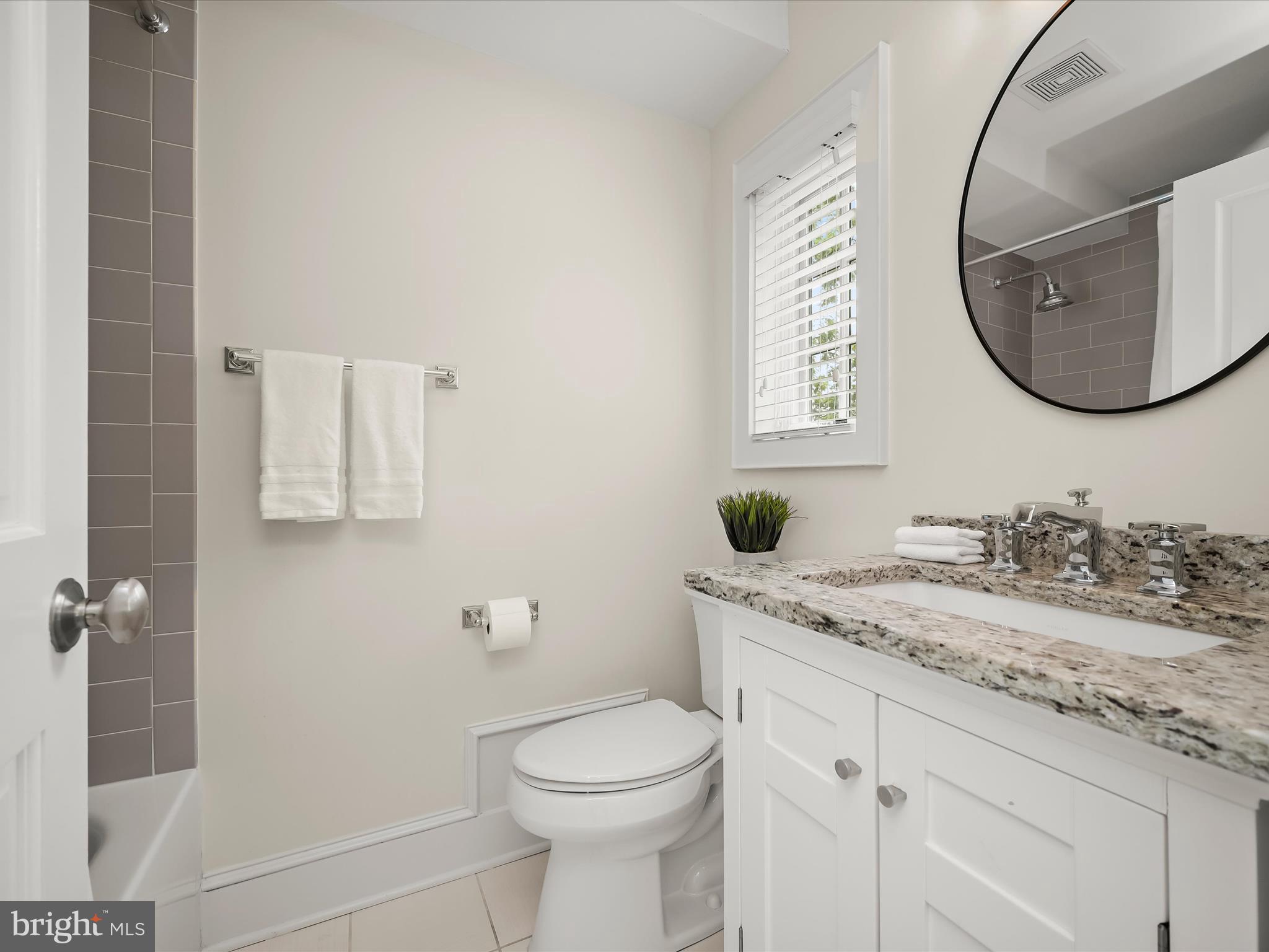 3118 17th Street North Arlington, VA 22201 - Photo 45 of 96 a bathroom with a granite countertop toilet sink and mirror