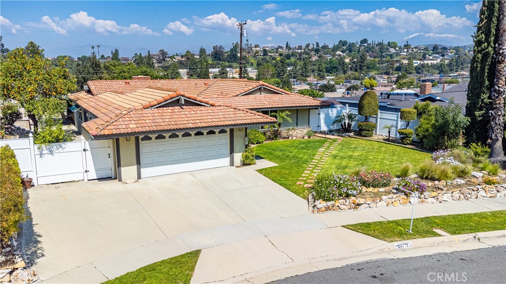 23711 Silver Spray Drive Diamond Bar, CA 91765 - Photo 3 of 49 a view of a white house with a yard plants and large tree