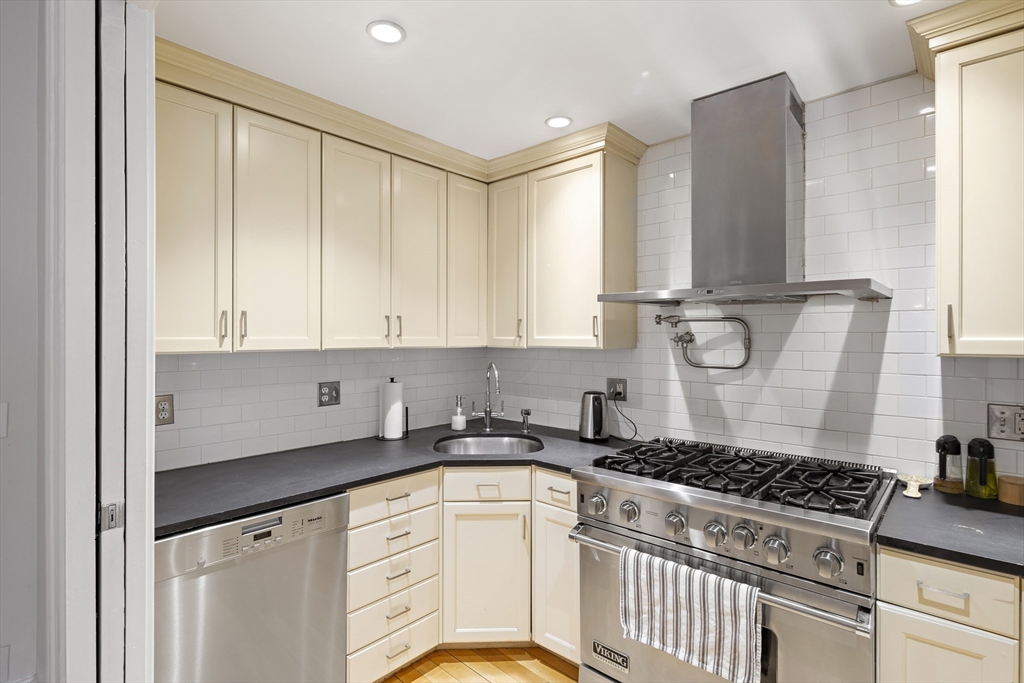 427 Shawmut Avenue, Unit 3 Boston, MA 02118 - Photo 8 of 26 a kitchen with granite countertop a stove a sink dishwasher and white cabinets with wooden floor