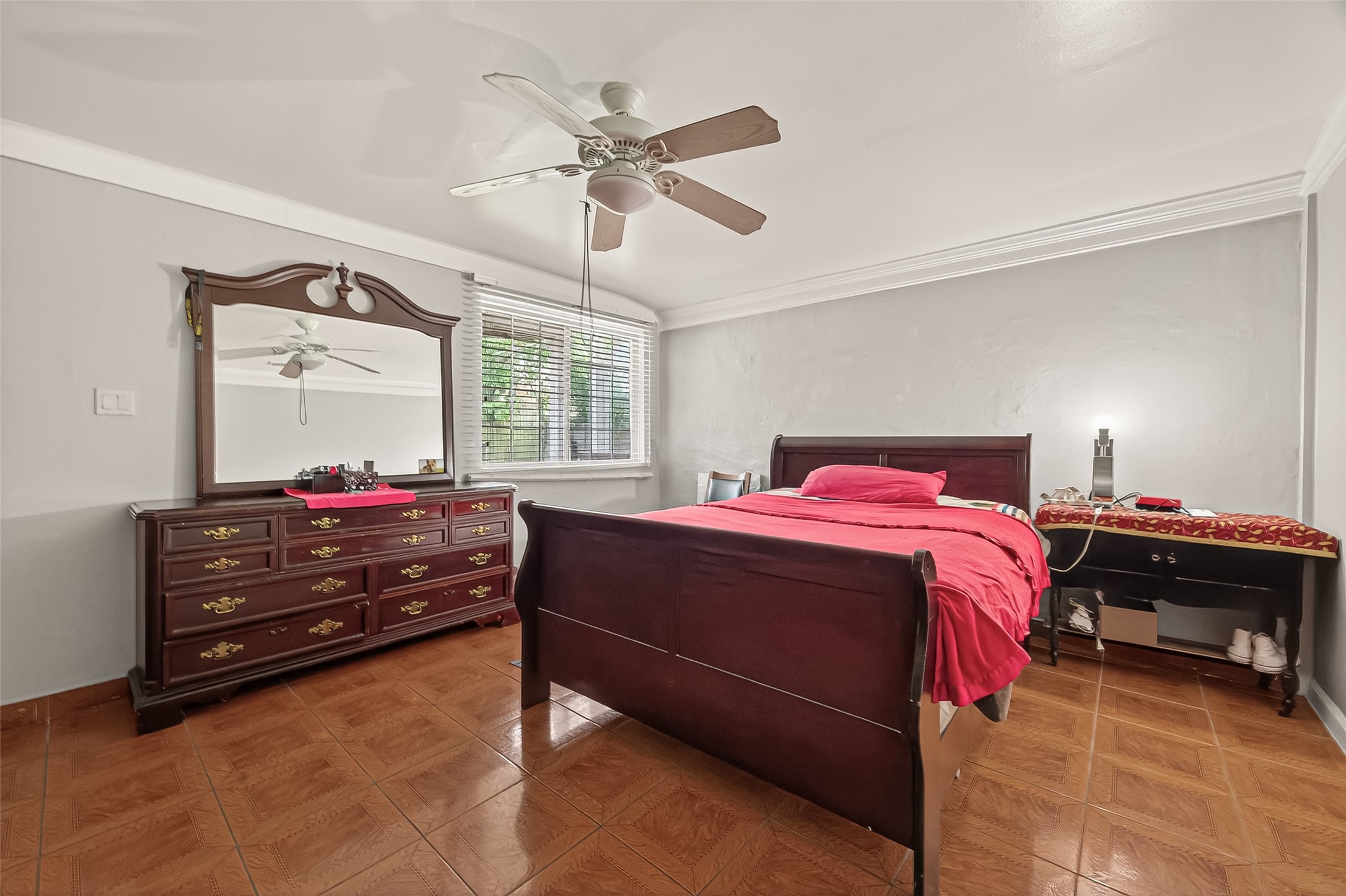 9030 Troulon Drive Houston, TX 77036 - Photo 12 of 34 Inviting bedroom featuring a ceiling fan, crown molding, and bright window with blinds, creating a comfortable retreat.