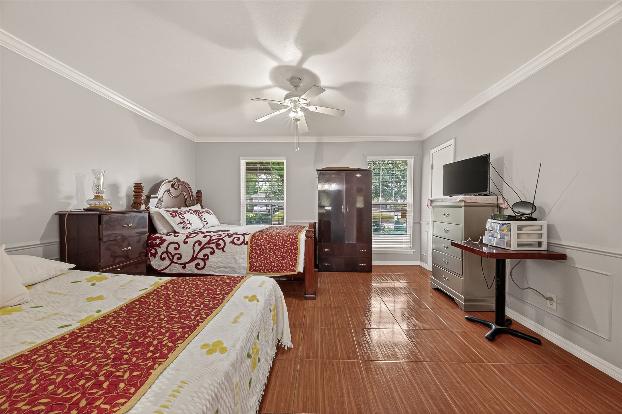 9030 Troulon Drive Houston, TX 77036 - Photo 15 of 34 Generous bedroom easily accommodating multiple beds, featuring glossy tile floors, two large windows, and a ceiling fan.