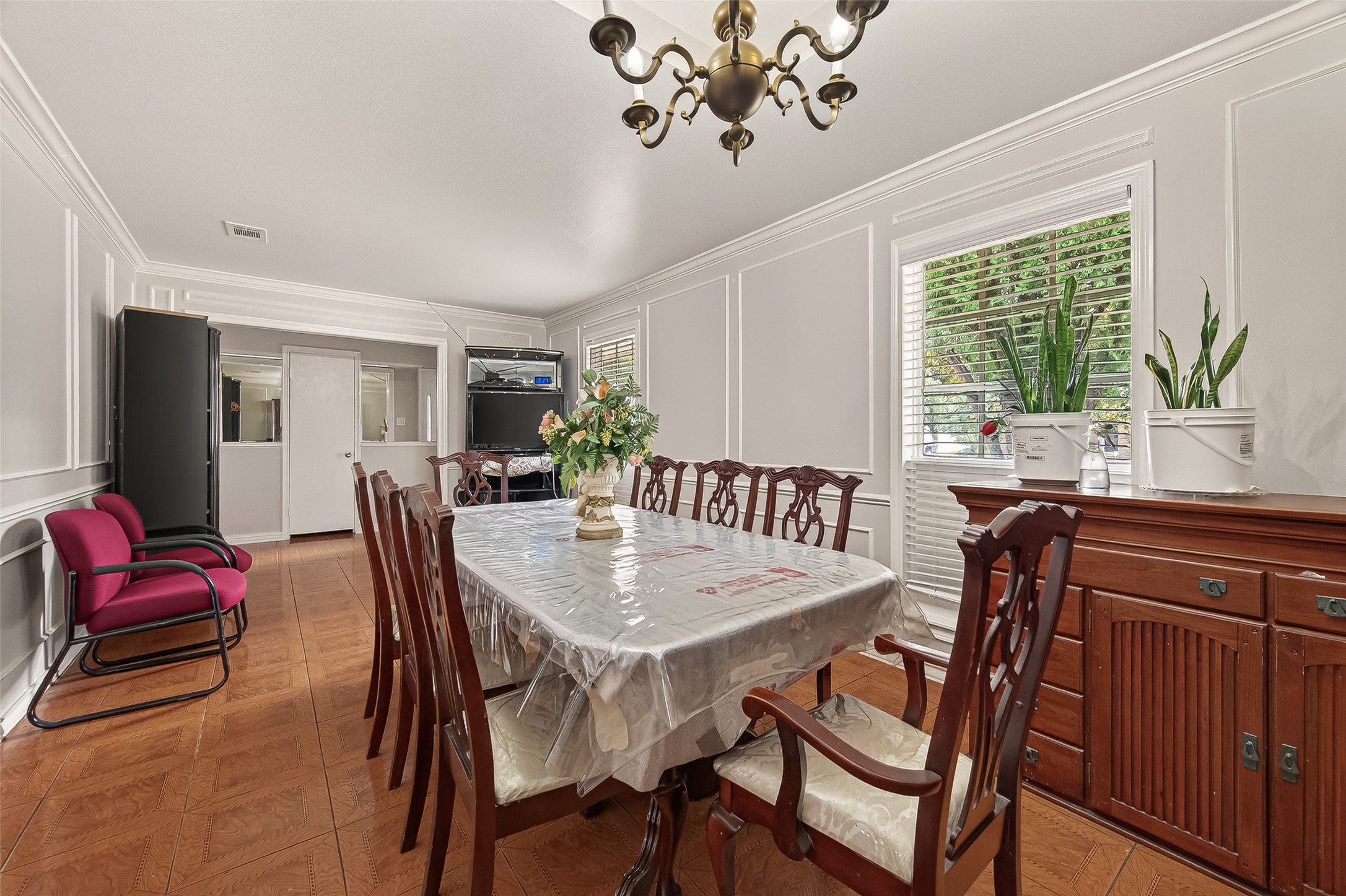 9030 Troulon Drive Houston, TX 77036 - Photo 8 of 34 Gracious dining area with expansive windows providing natural light, a large table setup, and stylish built-in cabinetry for storage.