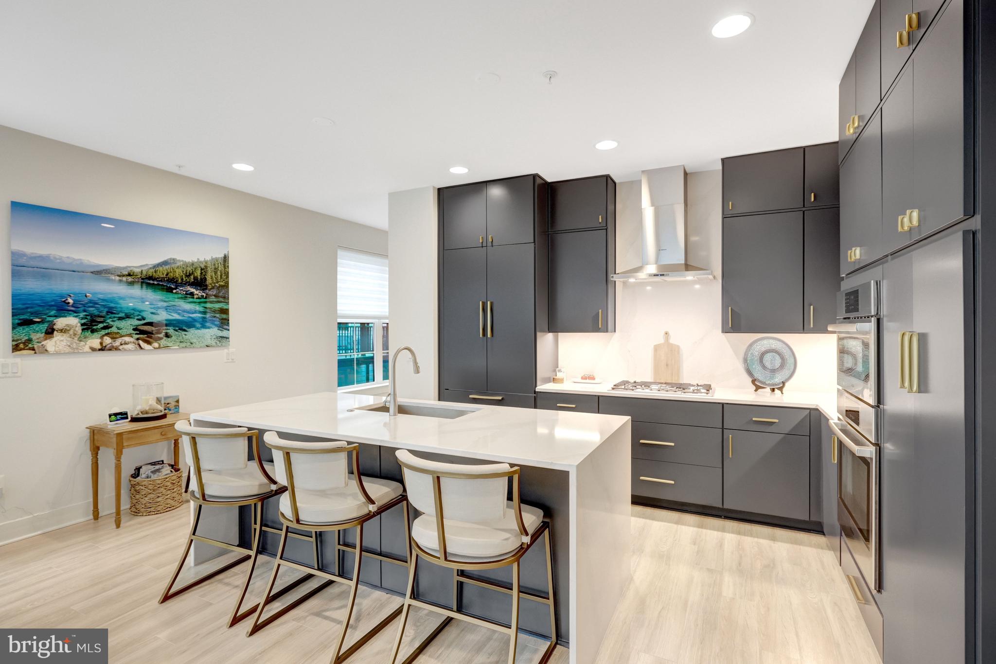 11236 Faraday Park Drive Reston, VA 20190 - Photo 17 of 74 a kitchen with stainless steel appliances kitchen island granite countertop a refrigerator and a stove top oven