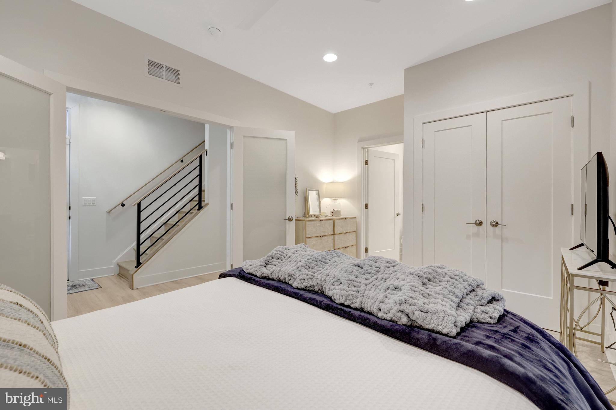 11236 Faraday Park Drive Reston, VA 20190 - Photo 8 of 74 a bedroom with a large bed and a chandelier